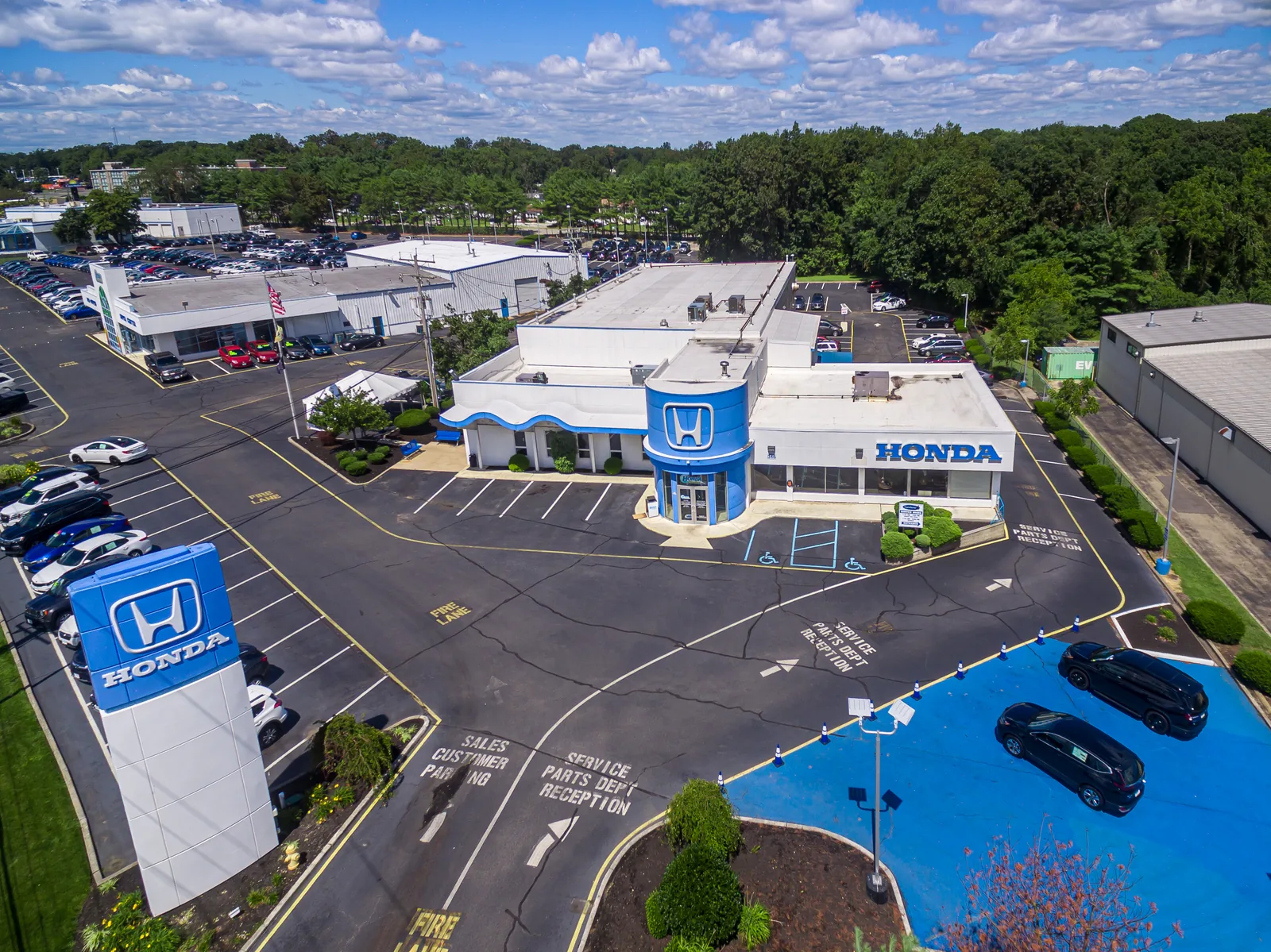 Dealership aerial composed around brand signage and the service entrance