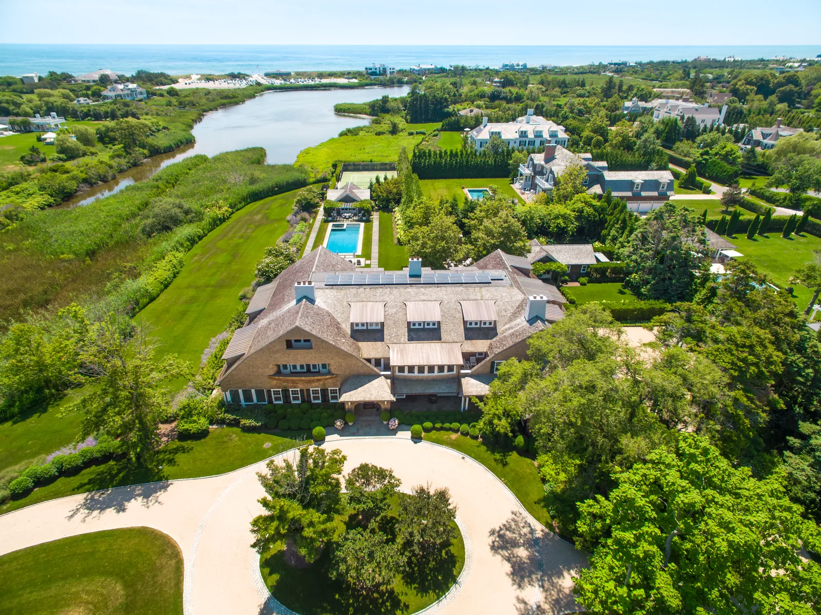 Estate aerial showing the house, pool, and pond across landscaped grounds