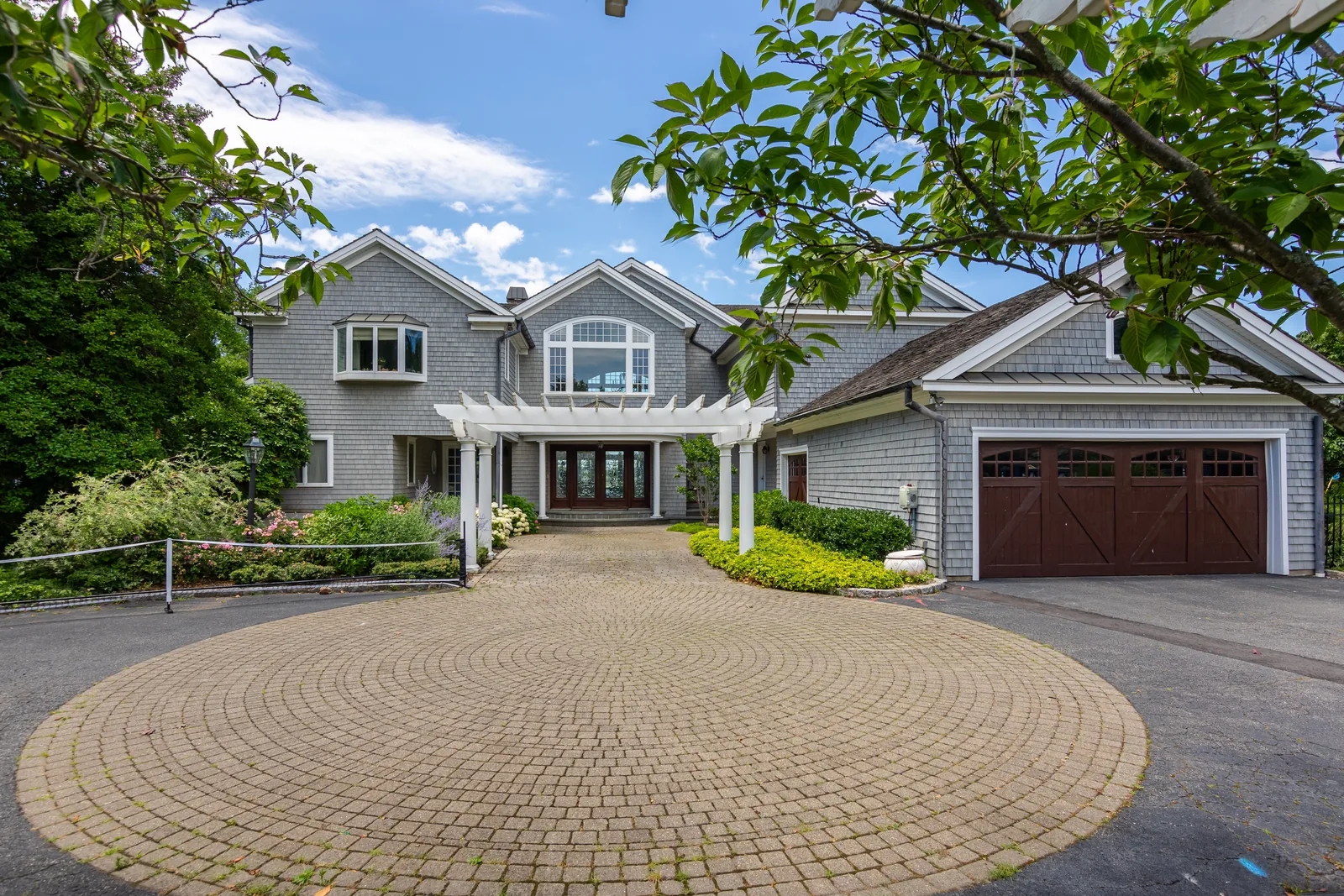 Luxury home aerial showing the paver drive, garage court, and landscaping