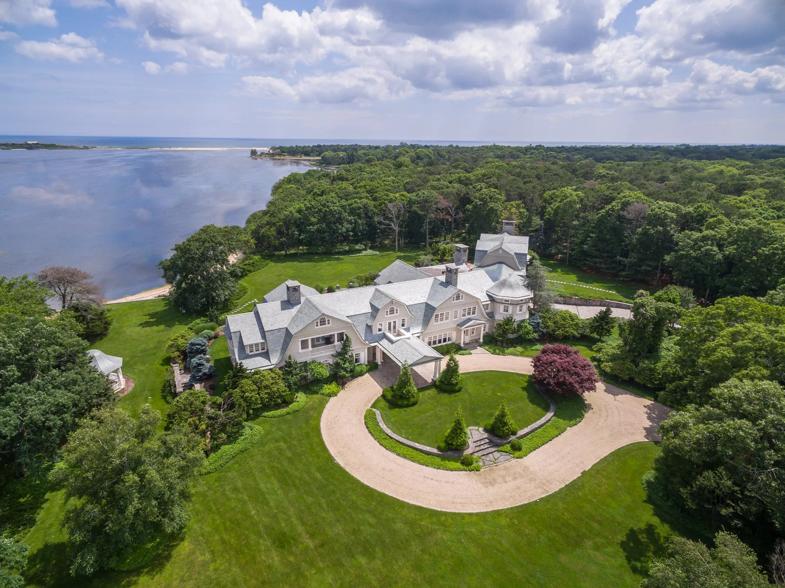 Manor-scale estate with circular drive and waterfront grounds, from the air