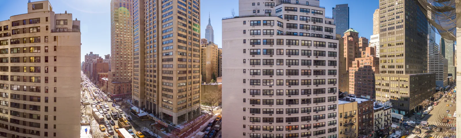 Rooftop panorama down a Midtown Manhattan avenue, towers on both sides