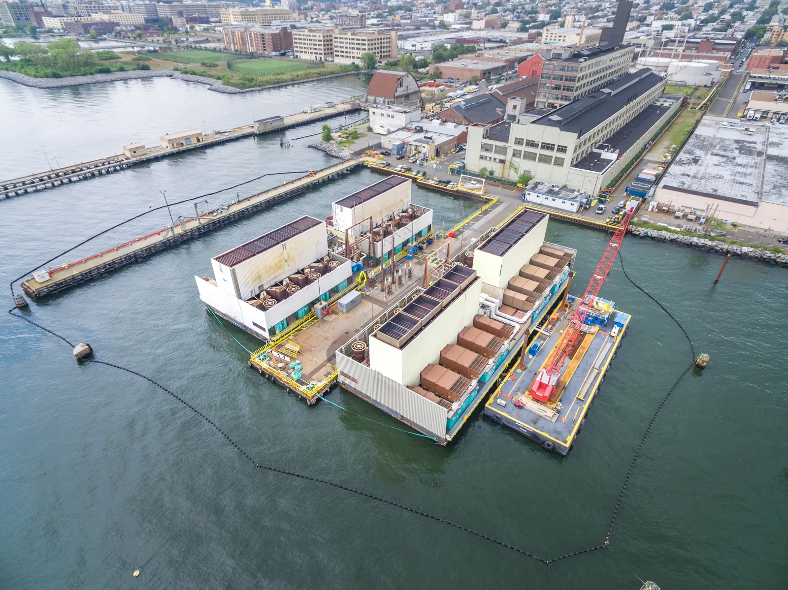 Floating generation barges at their pier, shot from altitude for an energy-sector client
