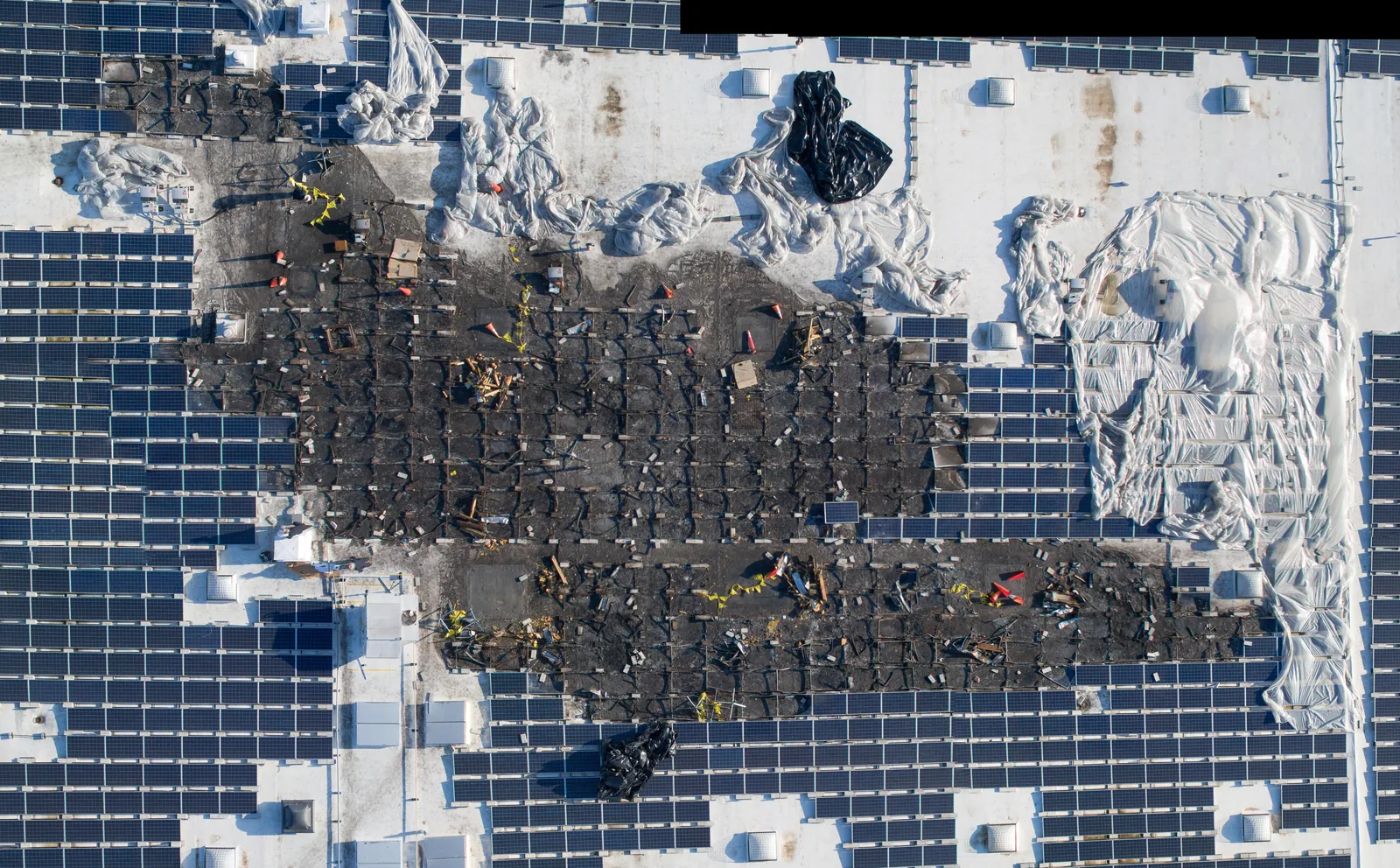 Straight-down overhead of a commercial rooftop solar installation in progress