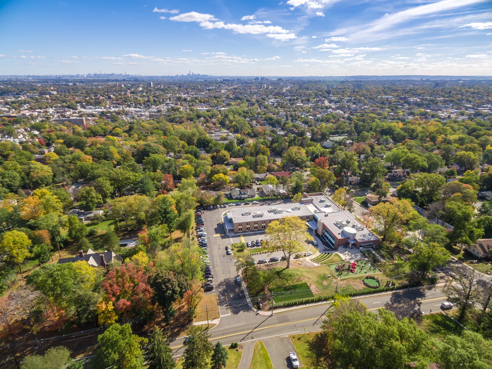 School campus aerial with the New York skyline faint on the horizon