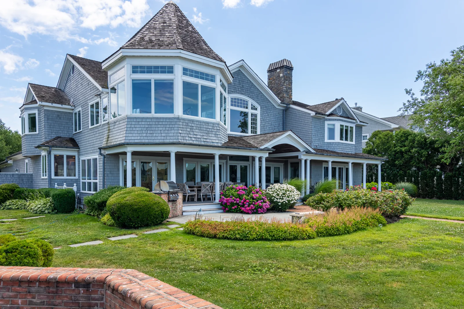 Three-quarter aerial of a shingle-style estate at golden hour