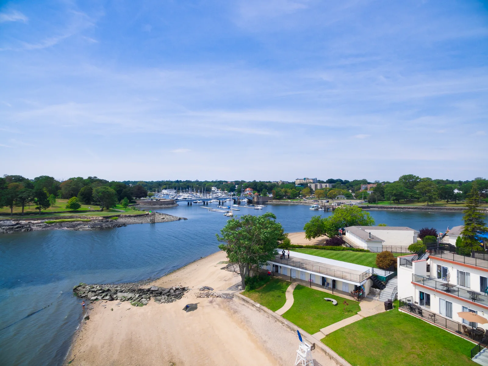 Waterfront club aerial: beach, boathouse, and channel to open water