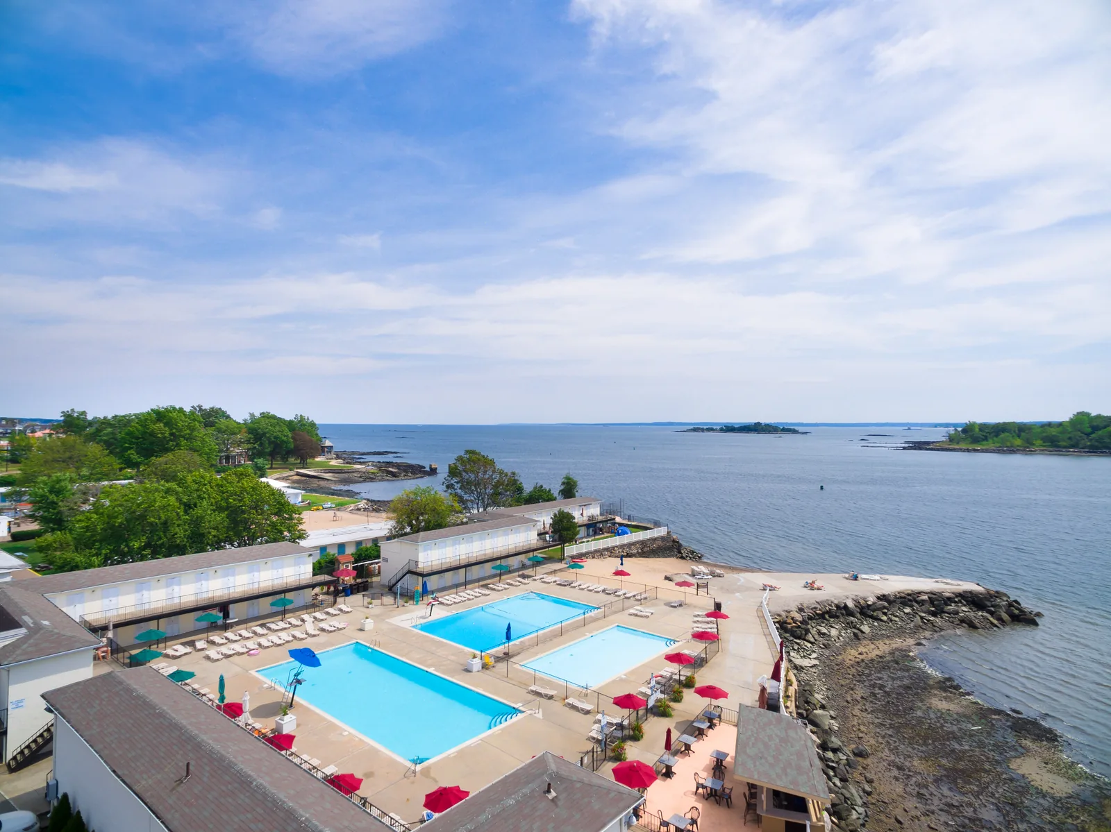 Club pool deck photographed from altitude with Long Island Sound stretching behind