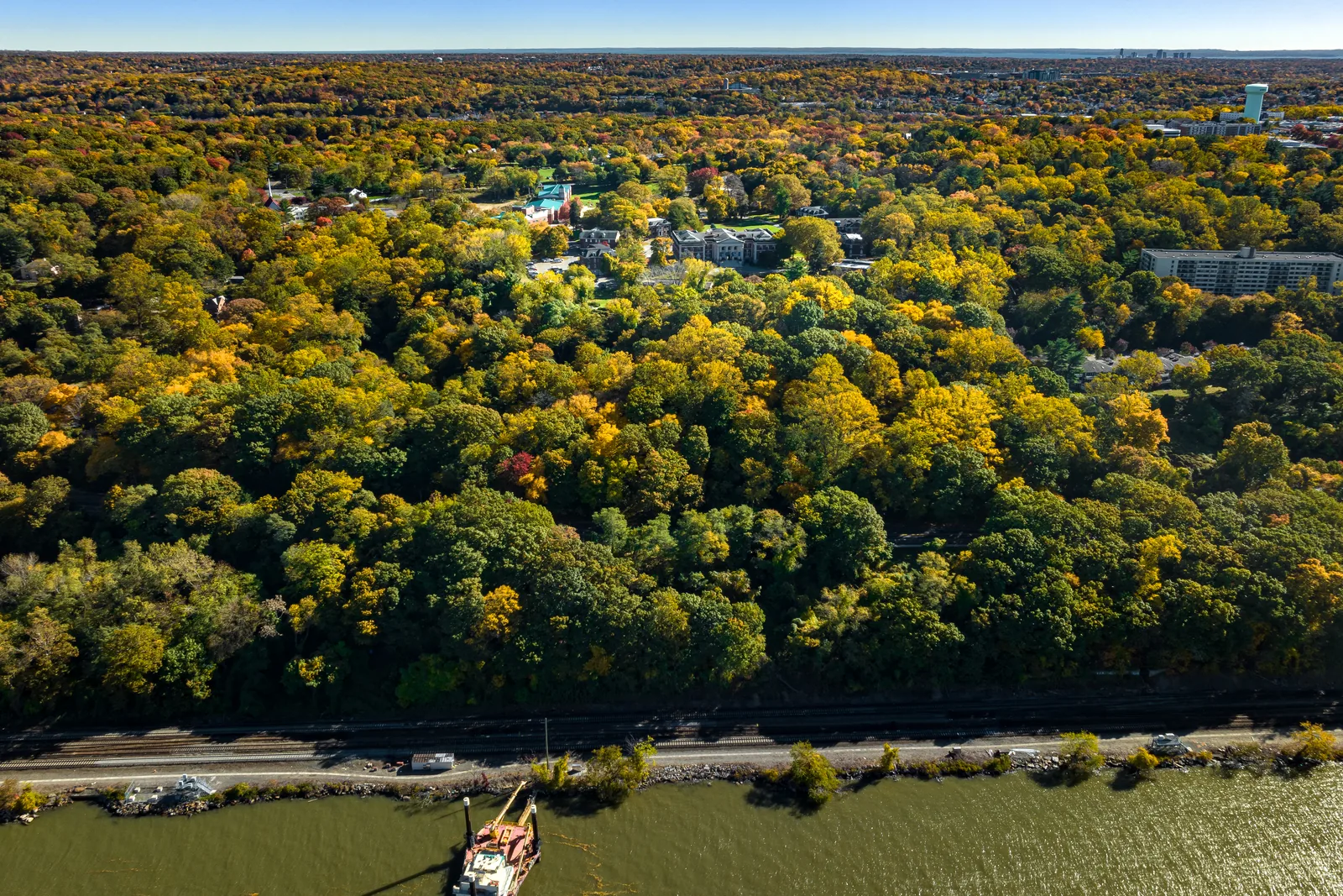 Wooded riverfront land in fall color, showing the tree cover and shoreline